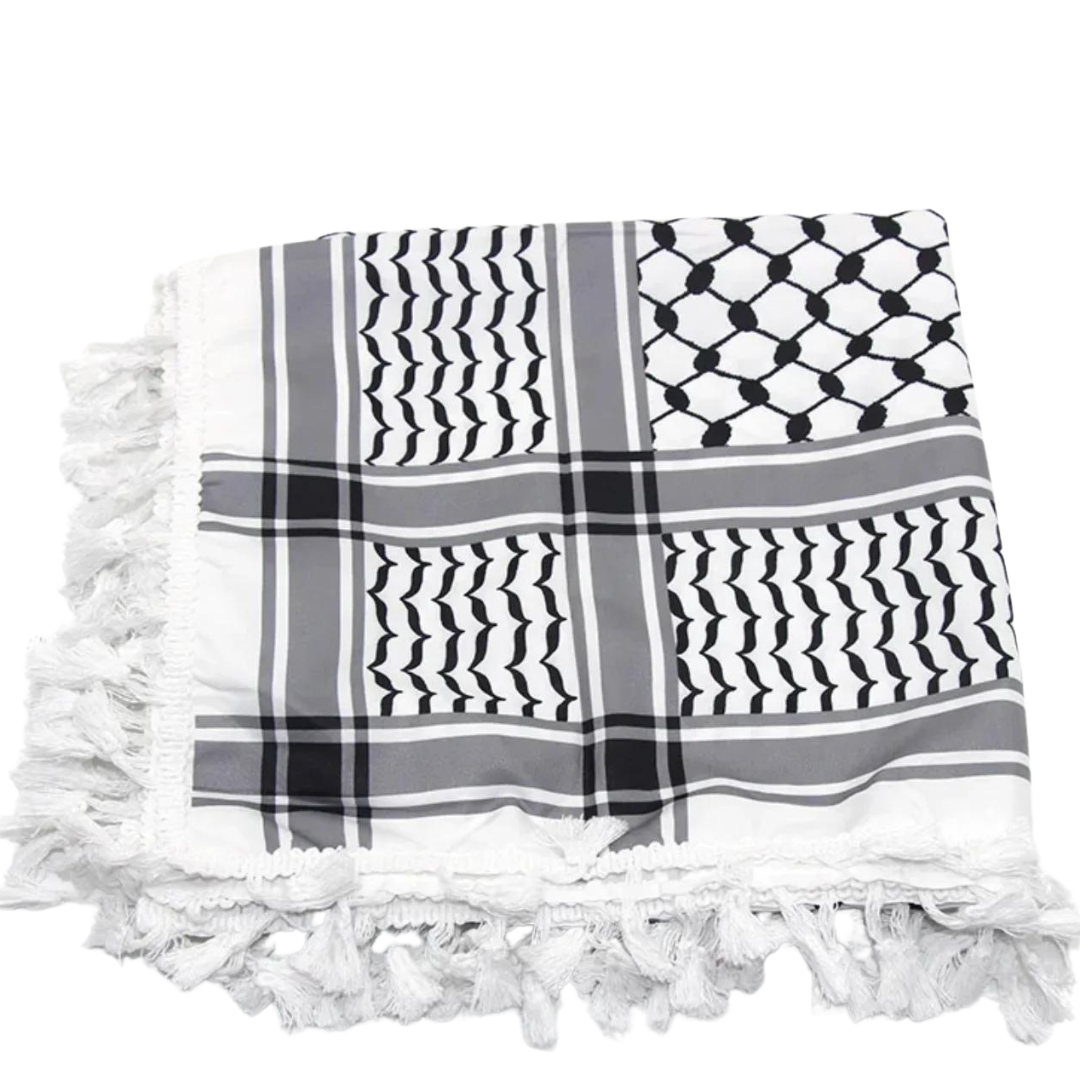 A white keffiyeh (traditional Palestinian headscarf) folded neatly on display. The scarf features a classic pattern of interwoven lines and geometric shapes, symbolizing cultural identity and resistance. The material appears soft and lightweight, perfect for both fashion and practical use. This keffiyeh is part of the "Shadow Resurgence" collection, emphasizing its modern, bold aesthetic while honoring its deep historical roots.